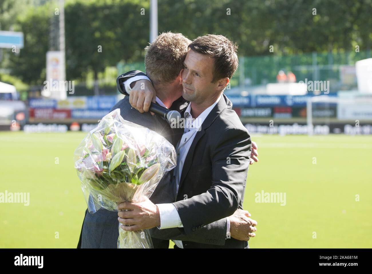 Outgoing manager of Stromsgodset FK and incoming manager of Scottish Premiership club Celtic Ronny Deila (R) is given flowers by Director of Football in Stromsgodset, Jostein Flo after half time of the match between Deila`s former club Stromsgodset and Haugesund in the Norwegian top football league in Drammen, 9 June 2014. Photo by Audun Braastad, NTB scanpix Stock Photo